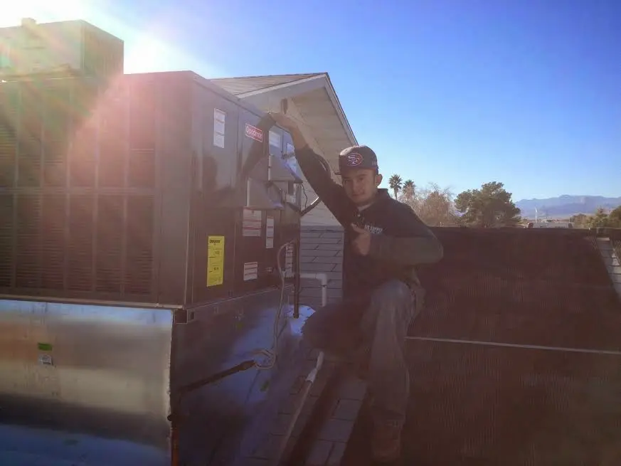 HVAC technician performing Boiler Repair on a rooftop unit in Perry